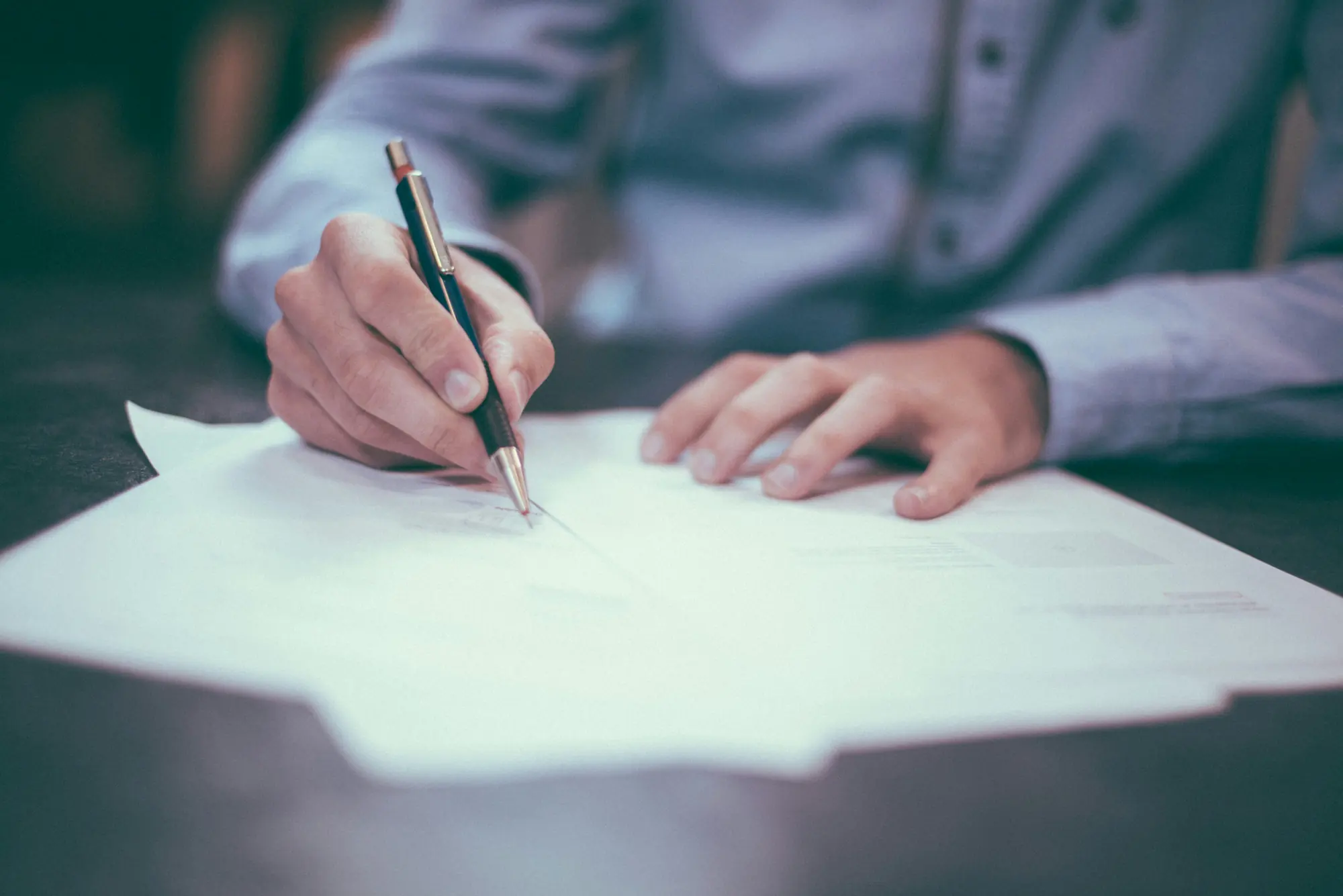 A hand annotating printed documents