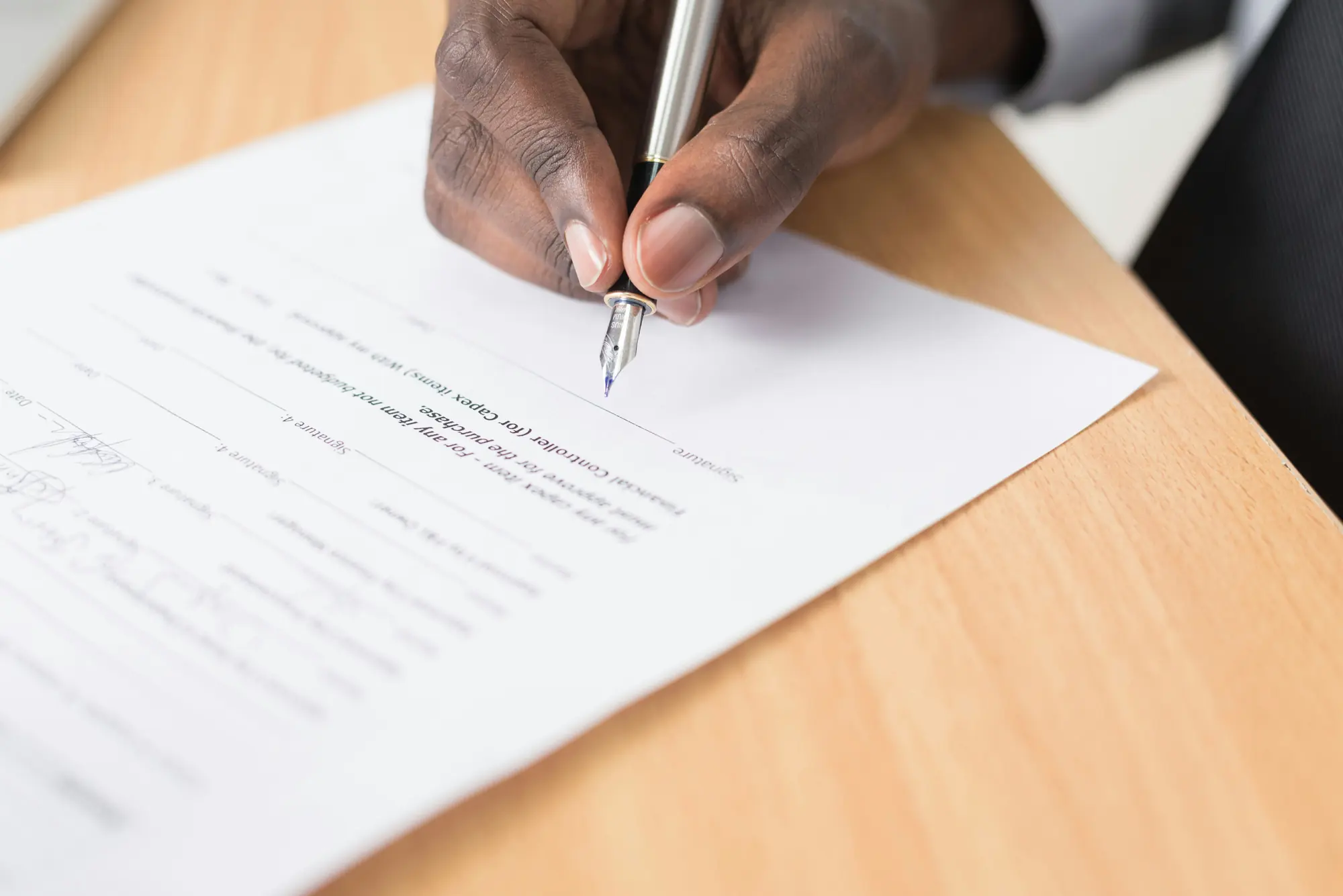 A hand signing an agreement